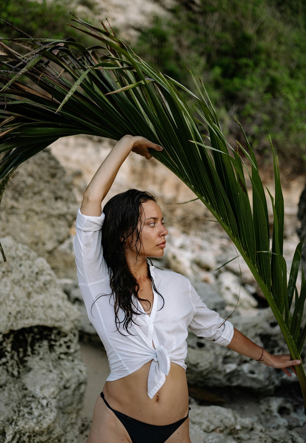 Editorial nude-inspired portrait on a rocky beach
